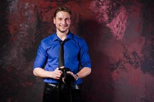 portrait en studio d'un photographe professionnel élégant avec appareil photo, porter une chemise bleue et une cravate. photo