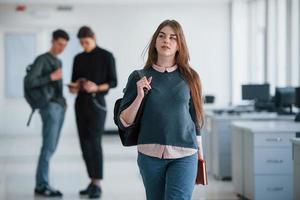 regard rêveur. groupe de jeunes marchant dans le bureau pendant leur pause photo