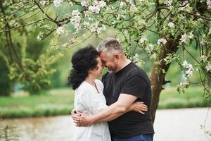 souriant et embrassant. couple joyeux profitant d'un bon week-end à l'extérieur. beau temps printanier photo