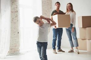 l'enfant s'amuse. la famille a été transférée dans une nouvelle maison. déballage des cartons de déménagement photo