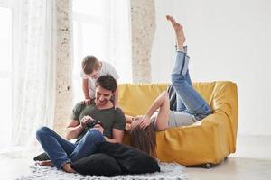 appareil photo d'époque. jeune couple avec enfant regardant ensemble les photos