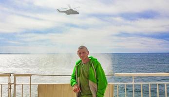 un hélicoptère militaire survole les touristes en ferry et la mer hirtshals danemark. photo