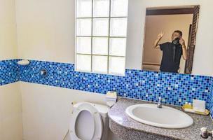 homme avec caméra dans la salle de bain miroir de l'hôtel phuket en thaïlande. photo