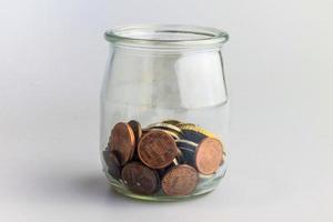 Finances personnelles et idée d'épargne avec des pièces dans un bocal.