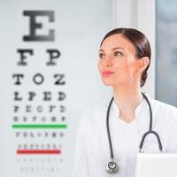 femme opticienne debout devant le test de la vue à l'hôpital