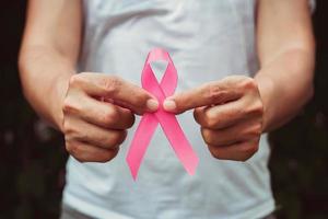 concept de soins de santé et de médecine. main tenant un ruban rose. la sensibilisation au cancer du sein. signe d'espoir photo