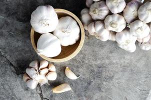 légume à l'ail dans un bol en bois sur fond de table en bois ancien photo