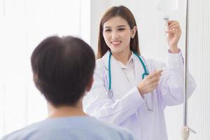 femme médecin asiatique regardant une goutte de solution saline pour les patients dans le concept de soins de santé et de protection contre les coronavirus. photo