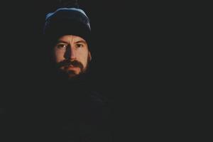 portrait d'homme avec barbe et bonnet de laine sur fond noir photo