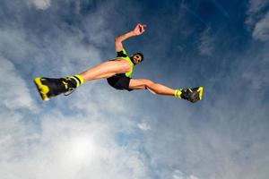 Athlète homme en sautant lors d'un trail running dans les montagnes photo