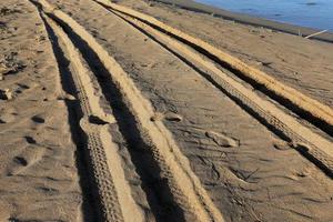 empreintes de pas dans le sable sur les rives de la mer méditerranée dans le nord d'israël photo