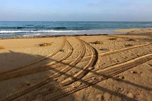 empreintes de pas dans le sable sur les rives de la mer méditerranée dans le nord d'israël photo