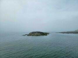 Pygargue à tête blanche sur l'île avec des rochers sur le rivage sur la côte du Maine photo