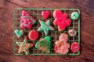 Biscuits de pain d'épice de noël décorés pour enfants colorés avec des saupoudres à plat photo