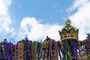 clôture en fer recouverte de perles de mardi gras surmontée d'une couronne dorée photo