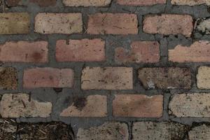 vieux fond de mur de texture de briques brunes, jaunes et rouges fissurées photo