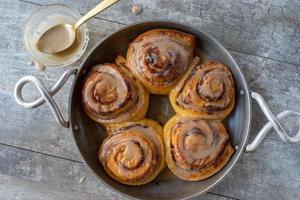 brioches à la cannelle à la citrouille cuites au four avec glaçage dans une poêle à plat photo