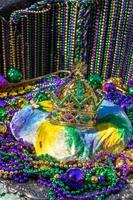 mardi gras king cake surmonté d'une couronne entourée de perles et de décorations photo