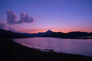 crépuscule ciel rivière coucher de soleil couleur pourpre paysage lac soir temps nuages et montagnes fond photo