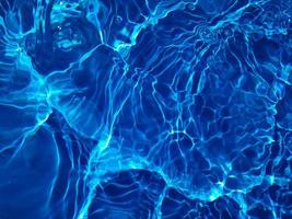 défocalisation aquarelle bleue floue dans l'arrière-plan détaillé de l'eau ridée de la piscine. éclaboussures d'eau, fond de pulvérisation d'eau. photo