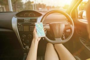 femme dans la voiture et tenant un téléphone portable avec navigation gps carte photo