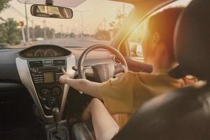 femme conduit une voiture dans la rue et ouvre la radio photo