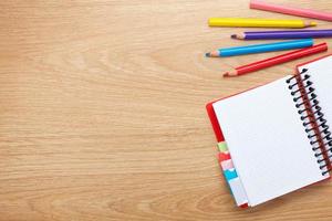 table de bureau avec bloc-notes vide et crayons colorés