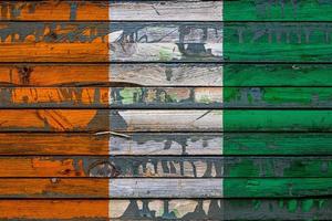 le drapeau national de la cote d'ivoire est peint sur des planches inégales. symbole du pays. photo