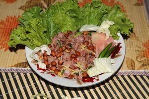 yum naem thai food - un plat traditionnel et audacieux, un plat que les thaïlandais préfèrent manger sur un sol en bambou tressé avec un motif de fleurs. photo