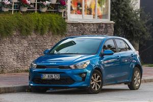 côté dinde 03 mars 2022 bleu kia rio est garé dans la rue par une chaude journée sur fond de jardin, clôture photo