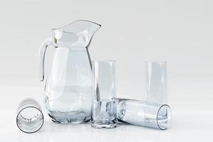 ensemble de vaisselle vide, carafe avec verres sur fond blanc isolé. concept de mode de vie sain photo