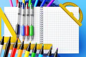 papeterie scolaire. crayons de couleur, stylos à encre de couleur, crayon ordinaire avec élastique rouge, règles, globe, pages de cahier vierges et autres sur fond bleu. Illustration 3D. photo