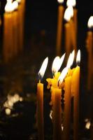 des bougies allumées dans une église sur un fond sombre photo