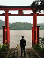 homme debout près de torii à hakone, japon photo