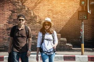 Sac à dos asiatique couple touriste tenant le plan de la ville traversant la route - concept de mode de vie vacances voyage personnes photo