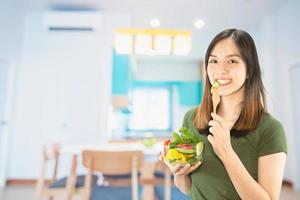 femme heureuse tenant des trucs de cuisine sur fond d'espace de copie - concept de préparation des aliments faits maison photo