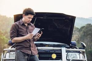 un homme essaie de résoudre un problème de moteur de voiture sur une route locale chiang mai thaïlande - les personnes ayant un problème de voiture concept de transport photo