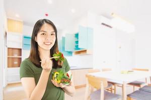 femme heureuse tenant des trucs de cuisine sur fond d'espace de copie - concept de préparation des aliments faits maison photo