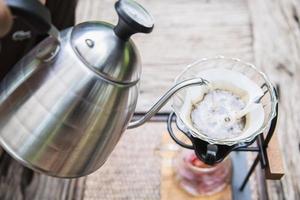 homme faisant goutte à goutte du café frais dans un café vintage avec fond de nature verte - personnes avec du café frais dans le concept de la nature photo