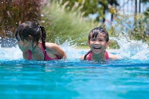 deux jolies petites filles jouant dans la piscine. concept de style de vie d'été. photo