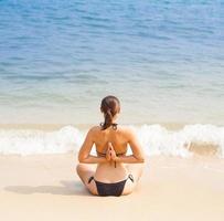 femme caucasienne, pratiquer le yoga sur la plage