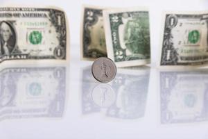 pièce de monnaie dirham des eau, sur fond de dollars américains en papier. espace de copie. photo