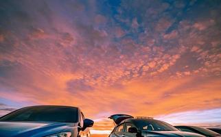 voiture garée sur le parking extérieur du camping avec un beau ciel coucher de soleil. voiture pour un voyage d'aventure. paysage naturel. road trip pour les vacances d'été avec des amis au parc de vacances. photo