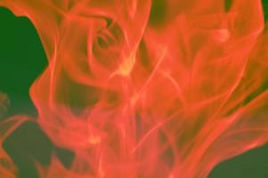 fumée orange rouge abstraite sur fond sombre, flammes. la conception du feu et le concept d'obscurité, de combustion. photo