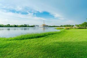 lac et champ d'herbe verte au parc. cycle de l'eau dans le lac près du pavillon. pelouse et jardin dans le parc en été. arbre vert et champ d'herbe. pique-nique en vacances. les gens se détendent et ont des activités dans le parc. photo