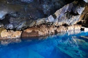 voir dans la grotte de lave de grjotagja avec une eau bleue cristalline. photo