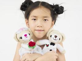 adorable enfant asiatique joue aux poupées d'ours de mariage photo