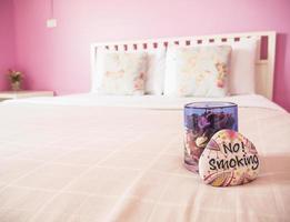 chambre couple rose avec panneau non fumeur sur un lit photo