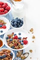 petit déjeuner avec granola, yaourt et petits fruits sur un bois blanc photo
