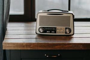 radio vintage rétro sur la surface de la table en bois près de la fenêtre. retour aux années 80. nostalgie musicale et concept de technologie ancienne. flûte à bec antique photo